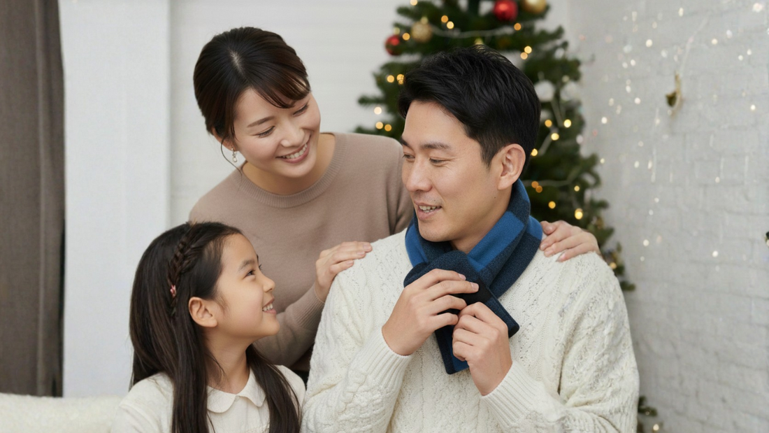 クリスマスギフトのTAKEO KIKUCHのミニマフラーを家族の前で着けてみる男性