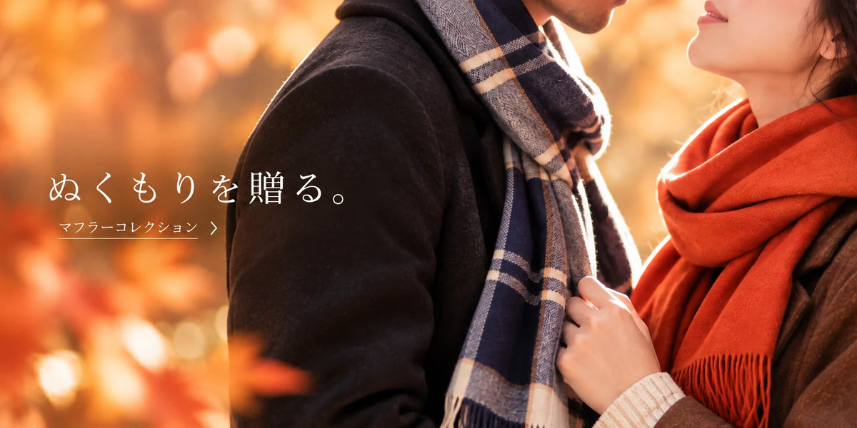 秋冬の温かな雰囲気の中、マフラーを身につけて寄り添う男女。大切な人へのクリスマスプレゼントにおすすめのマフラーコレクションを紹介するバナー画像。